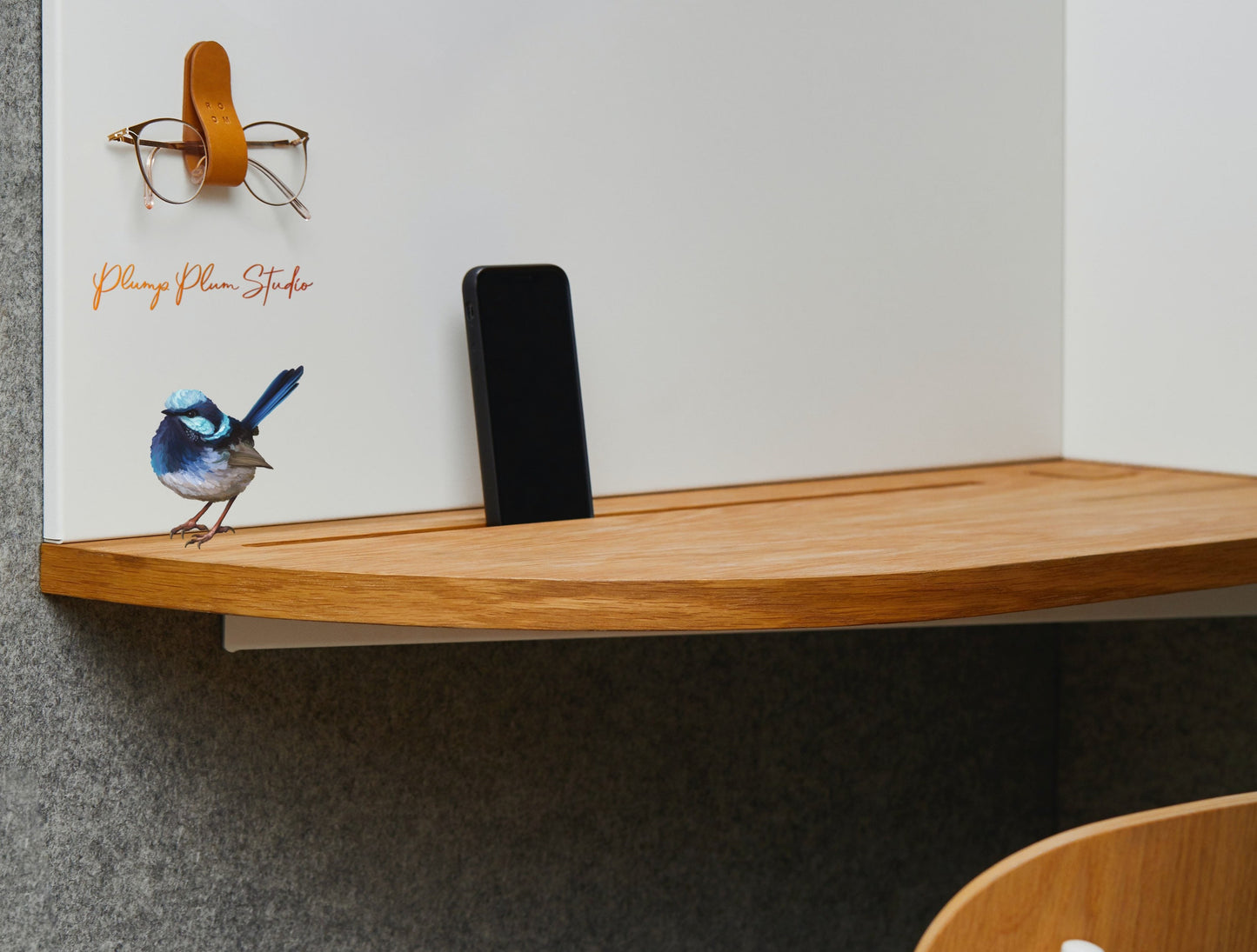 Small Blue Wren sticker perched realistically above a desk in a bright office, featuring a seamless borderless edge.