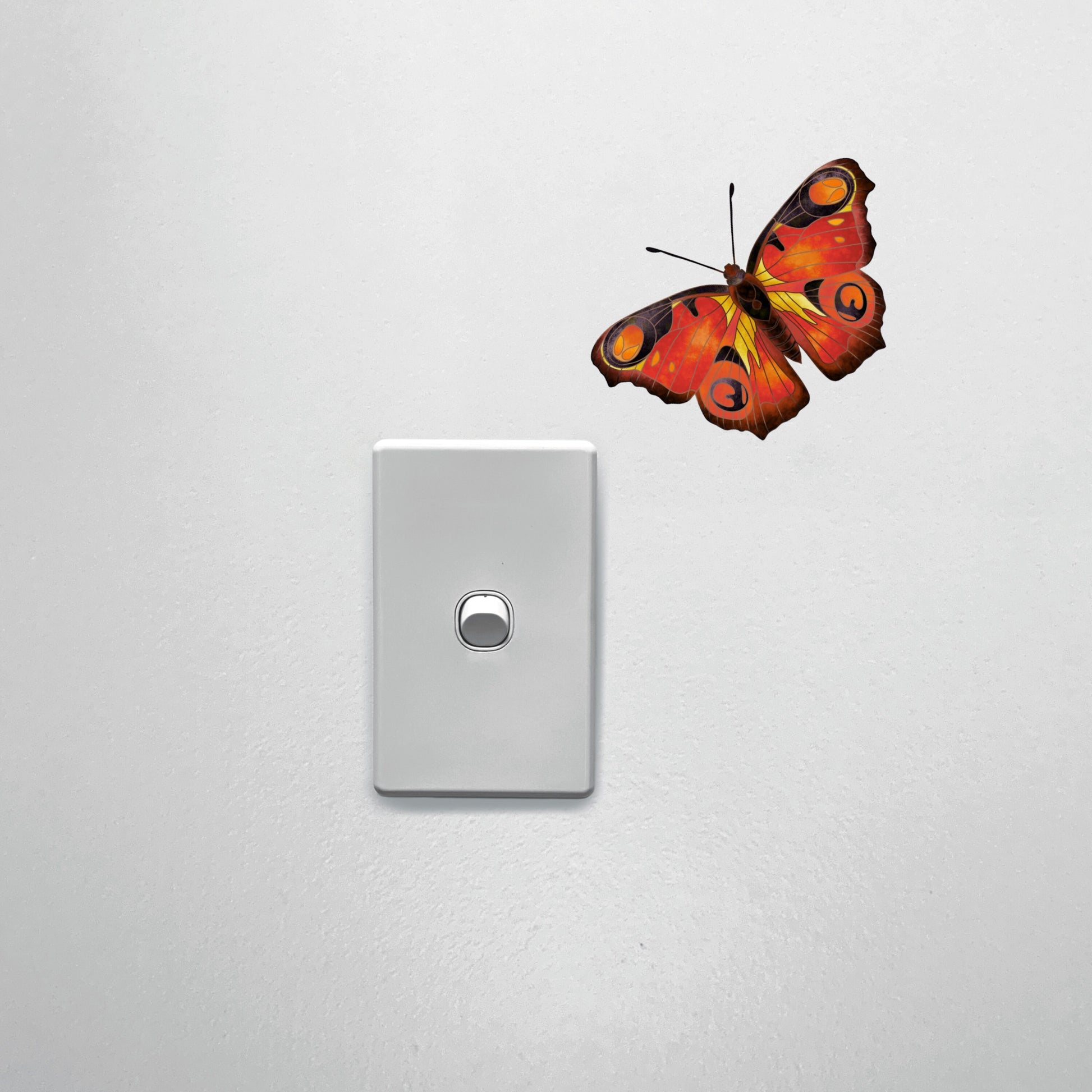 Life-sized orange butterfly wall sticker positioned above a light, creating a realistic nature-inspired accent.
