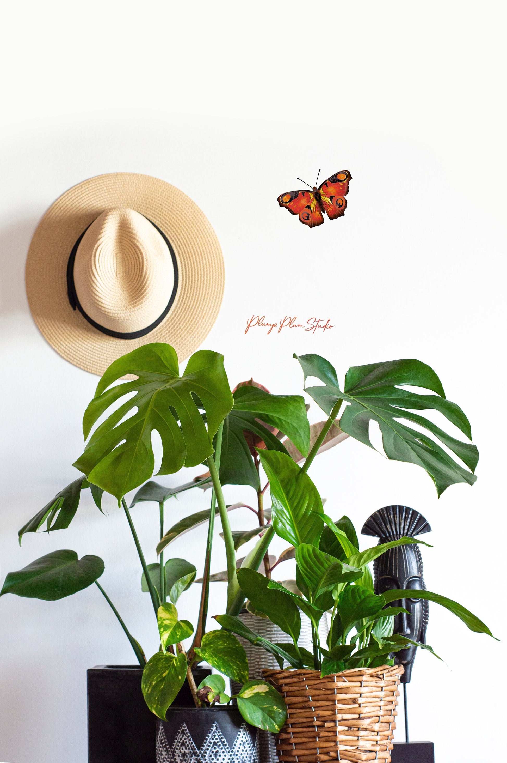 Life-sized orange butterfly wall sticker positioned on a white living room wall, creating a realistic nature-inspired accent.